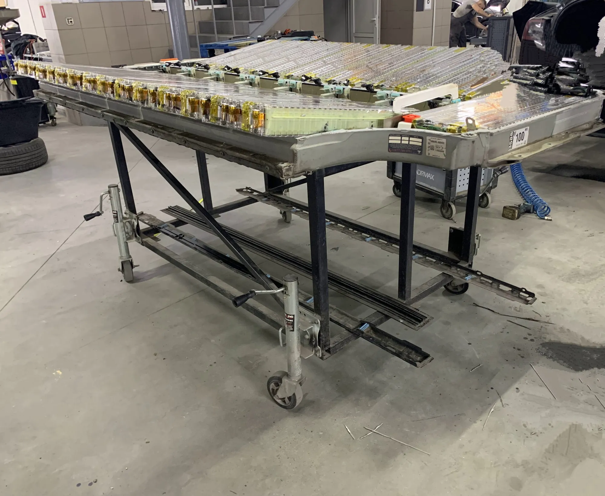 Tesla Model S high-voltage battery pack on a rolling service cart in shop