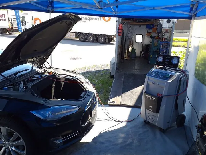Tesla Model S with hood open connected to AC recharge machine at TSK