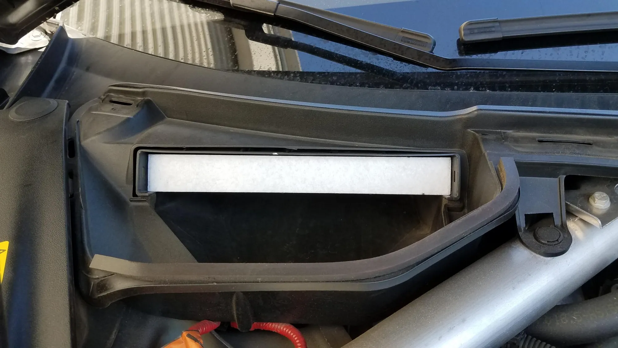 Tesla Model S cabin air filter housing under windshield during HVAC service at TSK