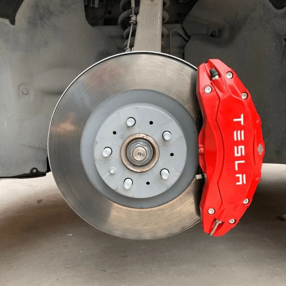 Tesla Model S front brake rotor and red Tesla caliper during suspension service at TSK