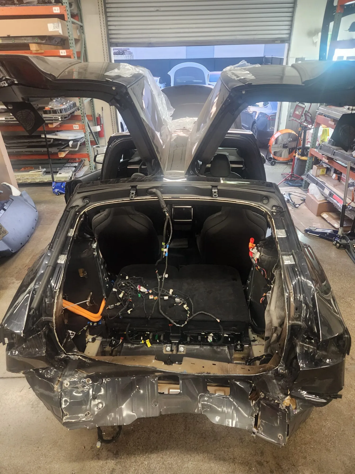 Tesla Model X rear end disassembled for frame straightening at TSK collision repair shop
