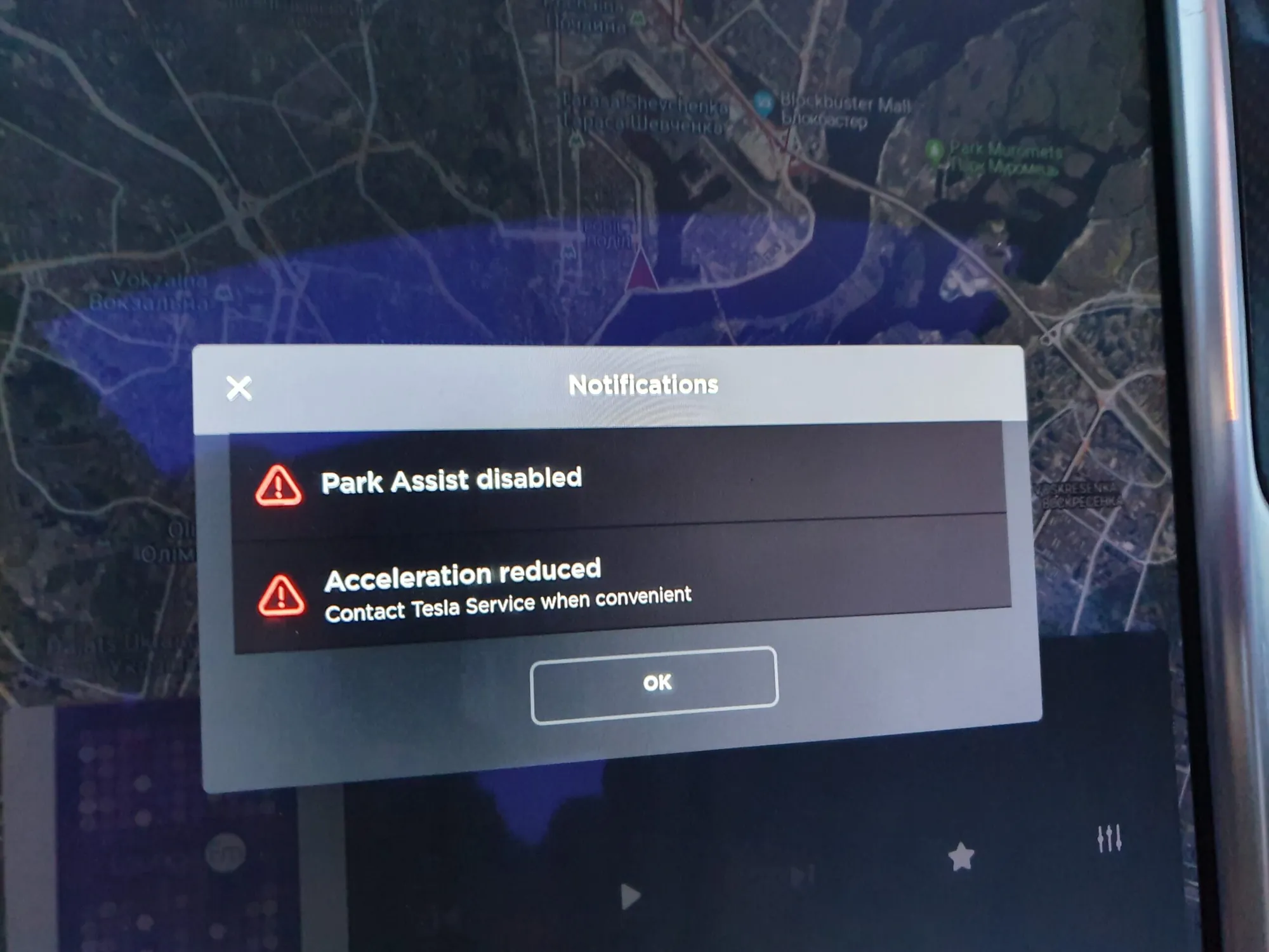 Tesla touchscreen showing Park Assist disabled and Acceleration reduced notifications