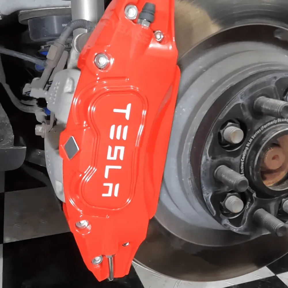 Tesla Model X front brake caliper installed, showing rotor and hub during service