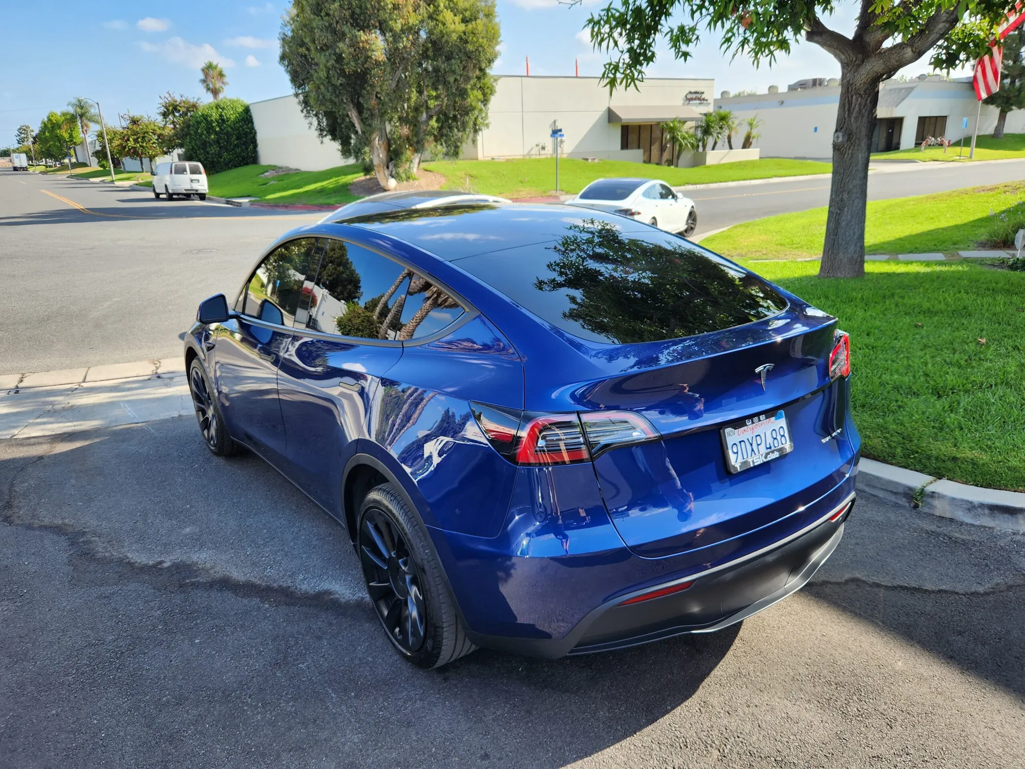 Blue Tesla Model Y rear view showing glossy body finish after repair