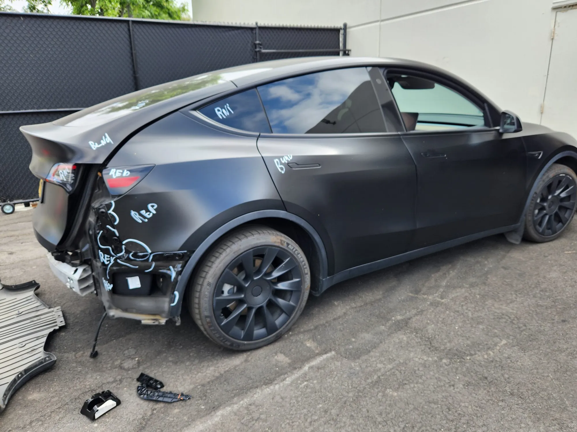 Black Tesla Model Y with rear bumper removed during collision repair at TSK