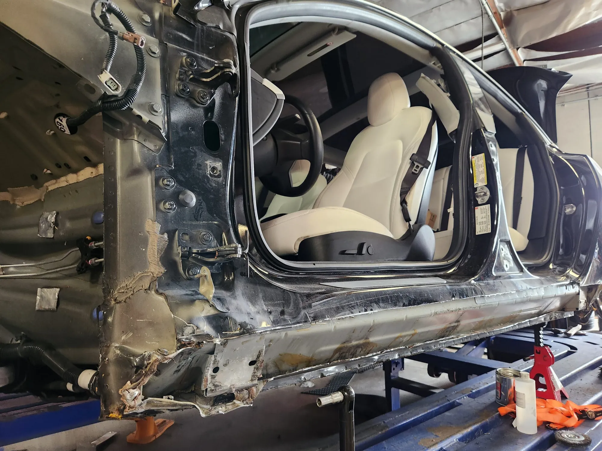 Tesla Model Y door frame and rocker panel exposed during collision repair at TSK