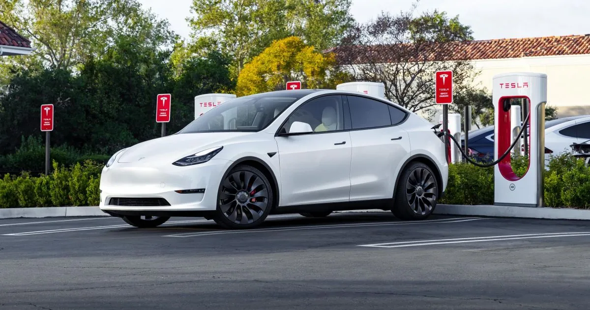 White Tesla Model Y plugged into a Supercharger for charging system troubleshooting