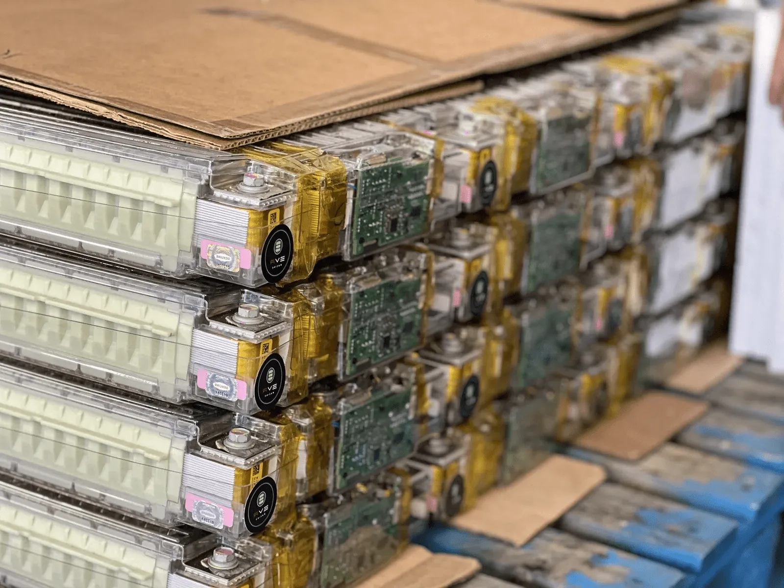 Stacked Tesla Model Y battery modules with circuit boards at TSK repair shop