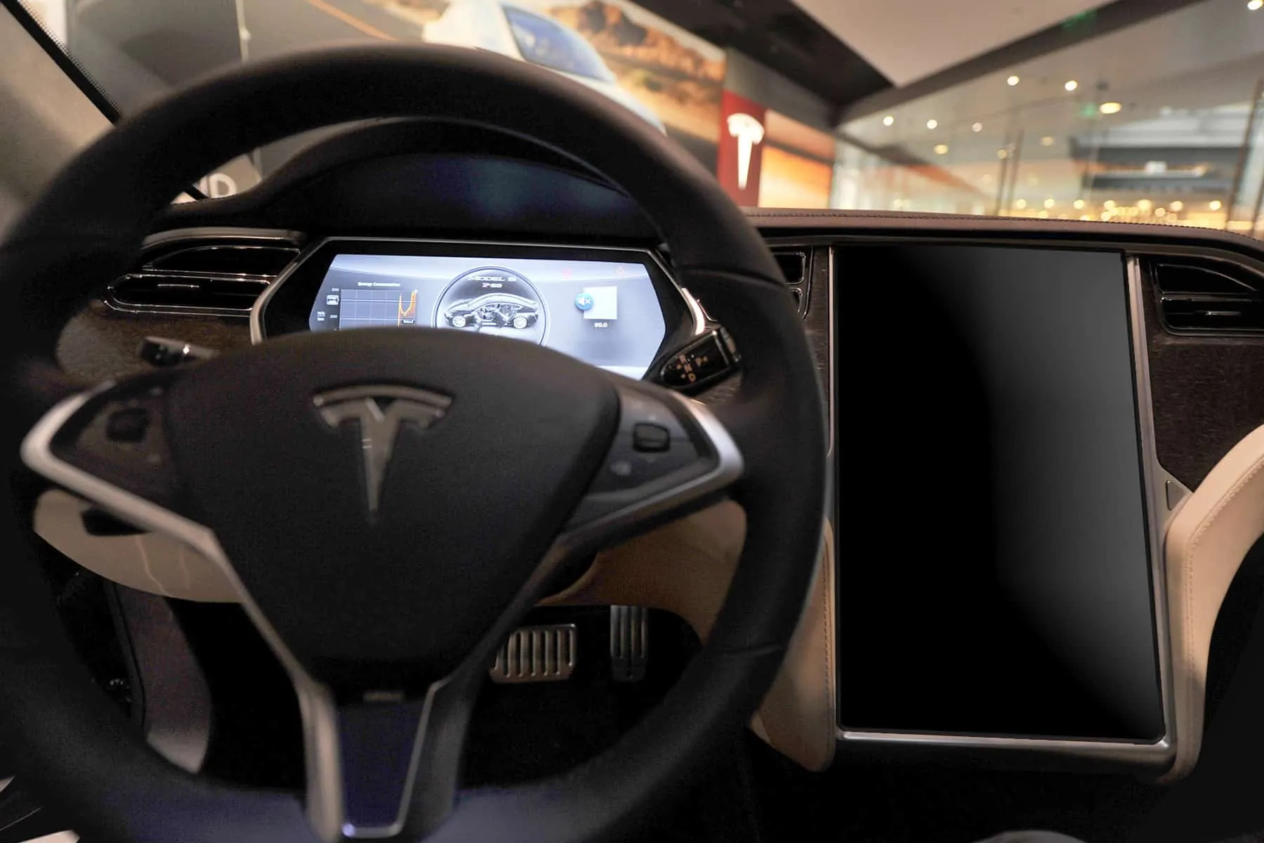 Tesla Model S interior with dark, unresponsive center touchscreen needing MCU programming