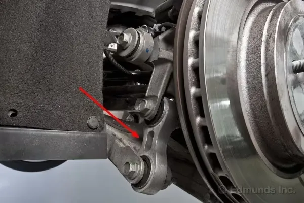 Close-up of front suspension steering knuckle and brake disc during EV repair inspection