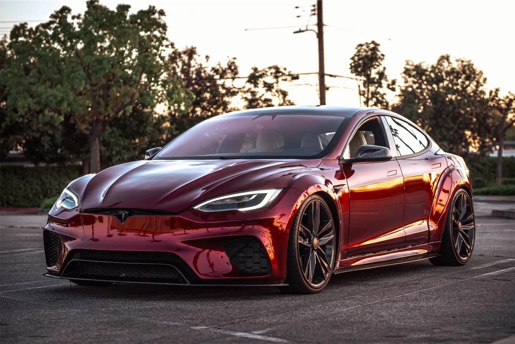 Wild Tesla project: candy red widebody Tesla Model S with black wheels, parked outdoors