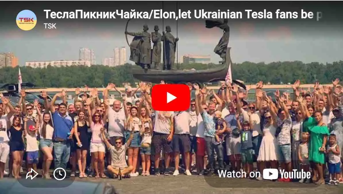 Large group of Tesla fans waving under Kyiv monument, YouTube video thumbnail