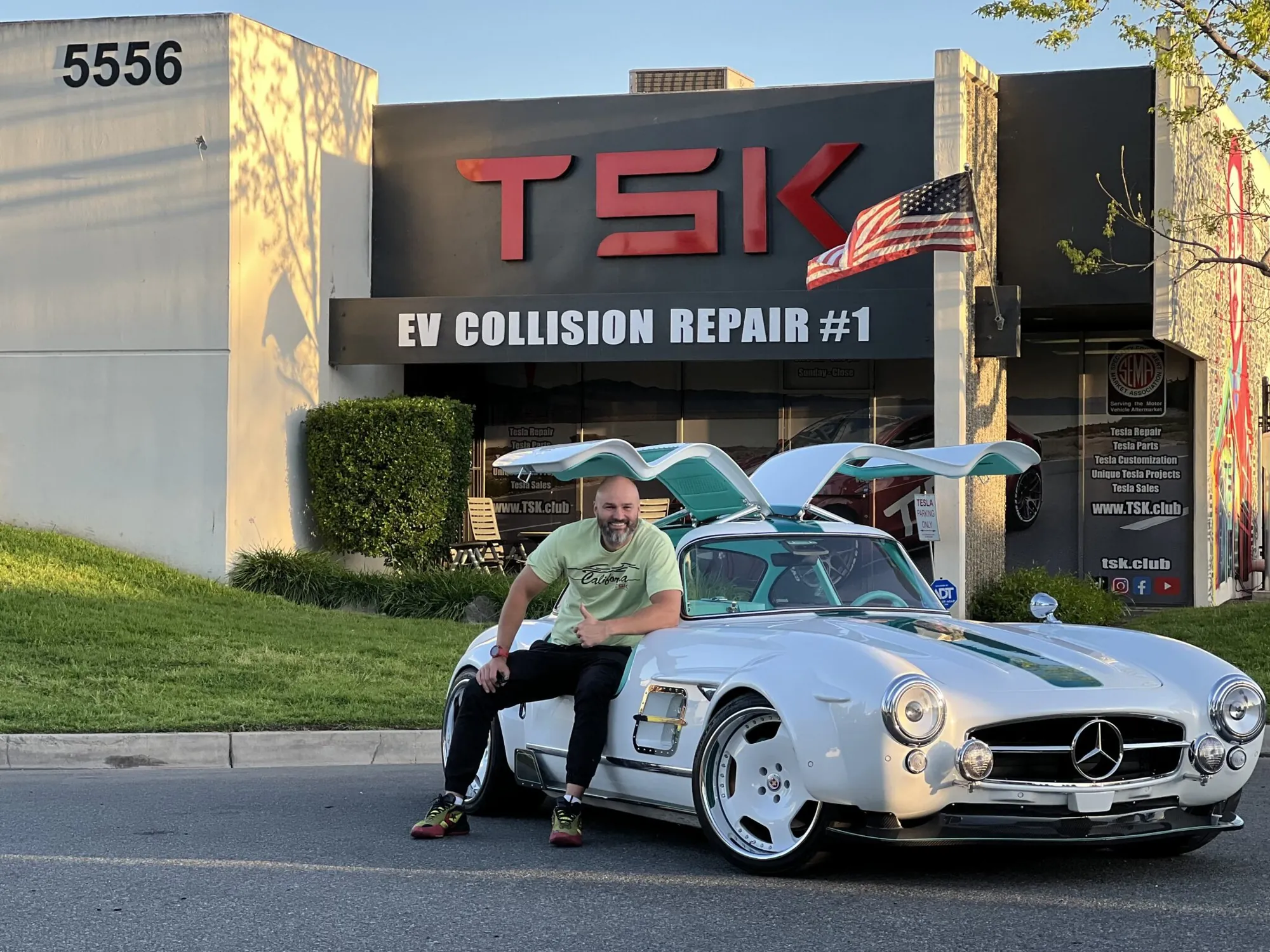 Tesla Gullwing project: man sitting on the white 300SL-style EV outside the TSK EV Collision Repair shop