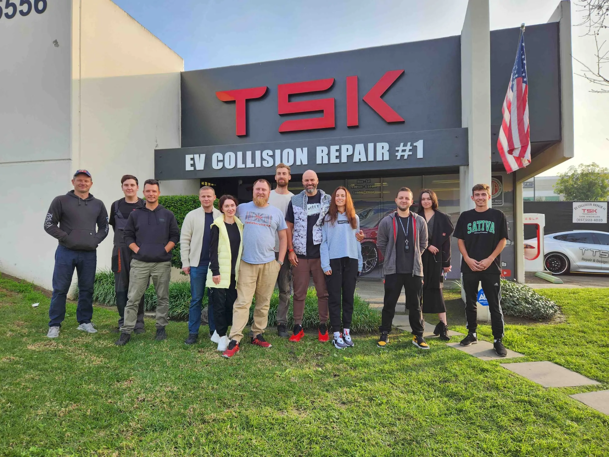 TSK EV Collision Repair team posing outside shop for 10th anniversary event