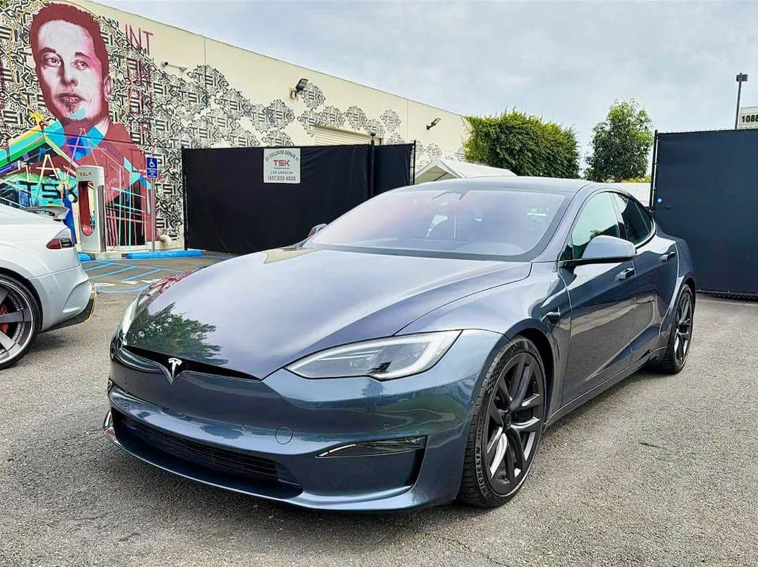 Dark gray Tesla Model S parked outside TSK EV collision repair shop
